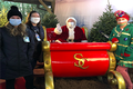 Image of 2 people wearing masks standing next to Santa and elf in masks